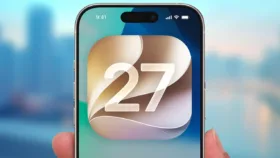 نمای گرافیکی از لوگوی iOS 27 روی صفحه نمایش آیفون در کنار متن معرفی ویژگی‌های جدید سیستم‌عامل اپل
